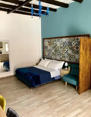 a bedroom with a large bed and a couch at LA CASA DELL'EMIRO in Misilmeri