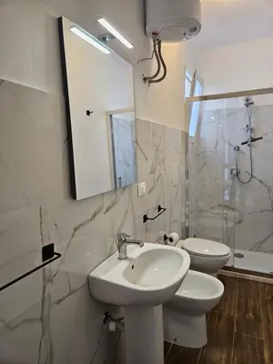 a bathroom with two toilets and a sink and a mirror at La Terrazza Bella Vista in Castellammare del Golfo