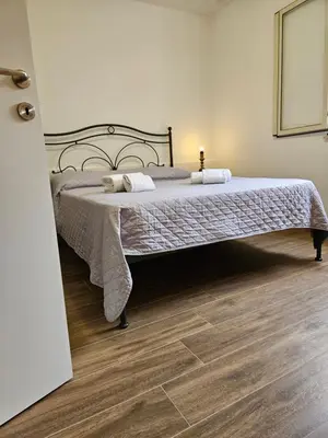 a bedroom with a bed and a wooden floor at La Terrazza Bella Vista in Castellammare del Golfo