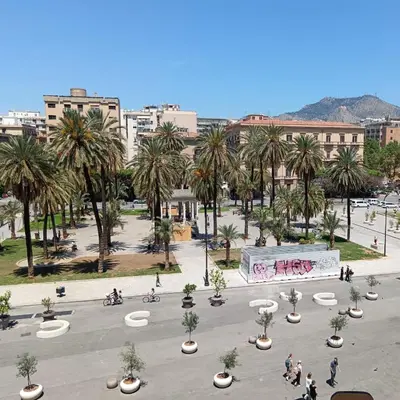 a city square with palm trees and a skate park at Politeama Suite in Palermo