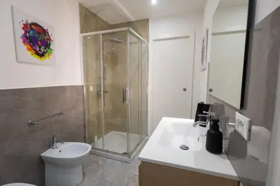 a bathroom with a shower and a toilet and a sink at Politeama Suite in Palermo