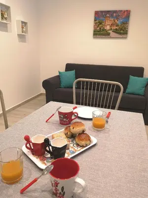 a table with a plate of food and cups of orange juice at Nora’s Home in Palermo