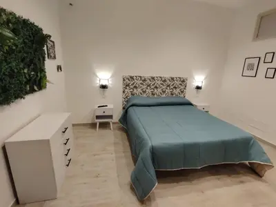a bedroom with a bed with a blue bedspread at Nora’s Home in Palermo