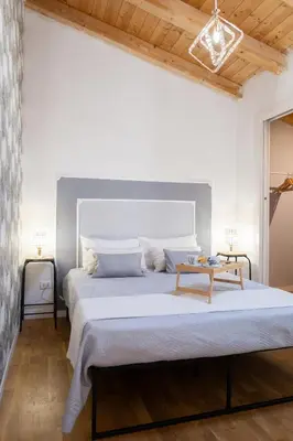 a white bedroom with a large bed and a table at La Cecia Home in Castellammare del Golfo