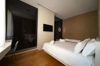 a hotel room with a white bed and a desk at Amorgiù Luxury Suites in Palermo