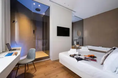 a living room with a white couch and a chair at Amorgiù Luxury Suites in Palermo