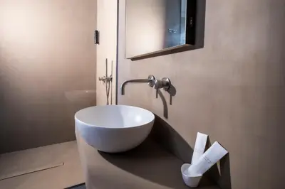 a bathroom with a bowl sink on a counter at Amorgiù Luxury Suites in Palermo