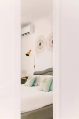 a white bedroom with a bed with green pillows at Villa delle Sterlizie con piscina e jacuzzi by Le Dhome Sicily in Partinico