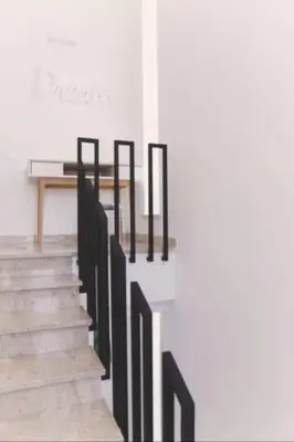a staircase with black railings and a table on the wall at Villa delle Sterlizie con piscina e jacuzzi by Le Dhome Sicily in Partinico