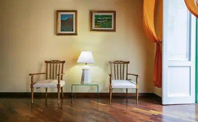 two chairs and a table with a lamp in a room at la Kalsa 14 nel centro storico di Palermo in Palermo