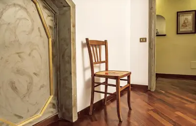 a wooden chair sitting in front of a mirror at la Kalsa 14 nel centro storico di Palermo in Palermo