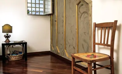 a chair and a wooden cabinet in a room at la Kalsa 14 nel centro storico di Palermo in Palermo