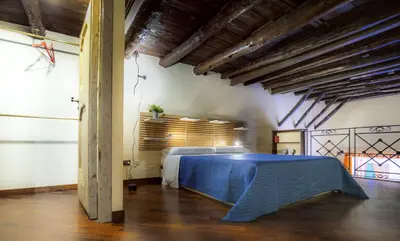 a bedroom with a bed in a room with wooden ceilings at la Kalsa 14 nel centro storico di Palermo in Palermo