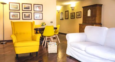 a living room with a white couch and yellow chairs at la Kalsa 14 nel centro storico di Palermo in Palermo