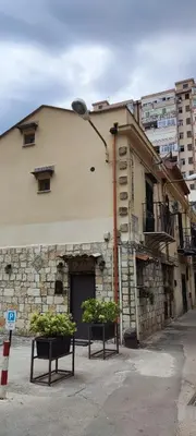 a building with two plants in front of a street light at Maison al-Aziz in Palermo