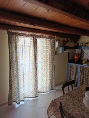 a kitchen with curtains and a table in a room at Maison al-Aziz in Palermo