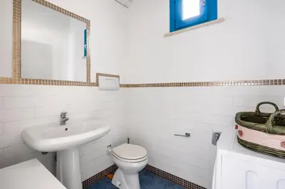 a bathroom with a white toilet and a sink at Villa Celeste in Castellammare del Golfo