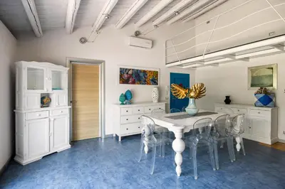 a dining room with a white table and chairs at Villa Celeste in Castellammare del Golfo