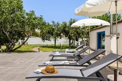 a row of lounge chairs and umbrellas on a patio at Villa Celeste in Castellammare del Golfo