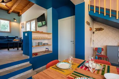 a dining room with blue walls and a table and chairs at Villa Maguetta with private pool in Scopello in Scopello