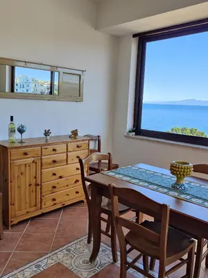 a dining room with a table and chairs and a window at Luna Marina - Sicilian beach house in Santa Flavia