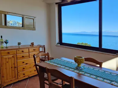 a dining room with a table and a large window at Luna Marina - Sicilian beach house in Santa Flavia