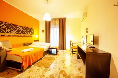 a hotel room with a bed and a desk and a bedroom at La Favorita - Ben collegato con l'aeroporto, la spiaggia di Mondello e il centro città in Palermo
