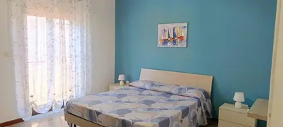a bedroom with a bed with a blue wall at Casa Vacanza Zá Cicciuzza in Isola delle Femmine