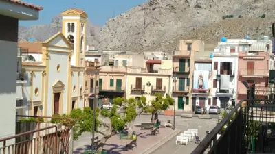 a view of a town with a mountain in the background at Casa Vacanza Zá Cicciuzza in Isola delle Femmine