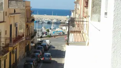 a view of a street with cars parked next to a harbor at Casa Vacanza Zá Cicciuzza in Isola delle Femmine