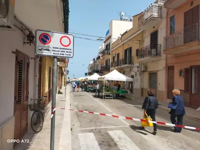two women walking down a street with a barricade at Casa Vacanza Zá Cicciuzza in Isola delle Femmine