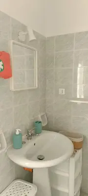 a bathroom with a white sink and a toilet at Casa Vacanza Zá Cicciuzza in Isola delle Femmine