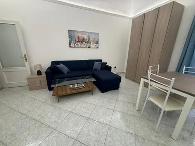 a living room with a blue couch and a table at Fauka blu in Carini