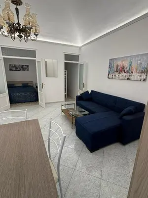 a living room with a blue couch and a table at Fauka blu in Carini