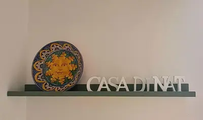 a plate on a shelf with a sign on a wall at Casa di Nat in Palermo