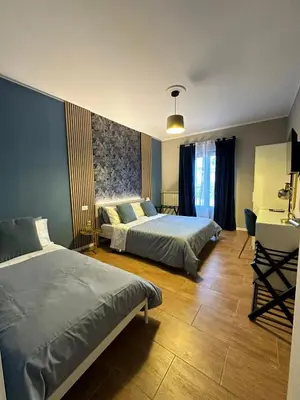 a bedroom with two beds and a desk at CentruMassimo Apartment in Palermo
