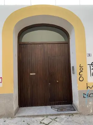 a wooden door in a building with graffiti on it at CentruMassimo Apartment in Palermo