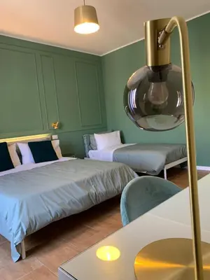 a room with two beds and a table with a lamp at CentruMassimo Apartment in Palermo