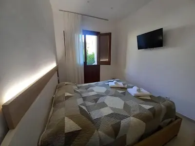 a bedroom with a bed and a television on the wall at Un tocco di San Vito in San Vito lo Capo