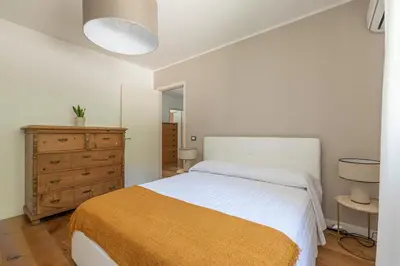 a white bedroom with a bed and a dresser at Villa Nika in Palermo