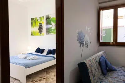 a bedroom with a bed with blue sheets and a mirror at STELLA BLU in Calatafimi