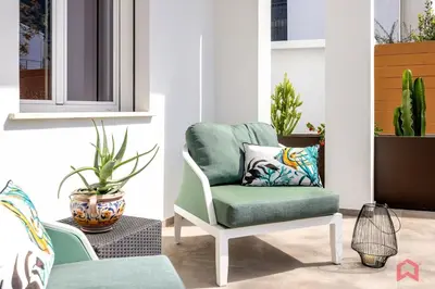 a living room with a green chair and plants at Appartamento in villa con piscina privata in Palermo