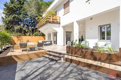 a patio with chairs and a table in a house at Appartamento in villa con piscina privata in Palermo