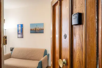 a room with a door with a couch and a chair at [MoroHouse] 50mt from Teatro Massimo in Palermo