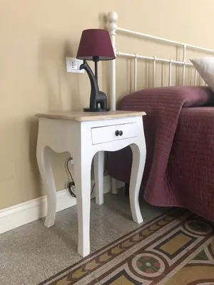 a white table with a lamp on it next to a bed at Appartamento Vento D'Estate in Bagheria