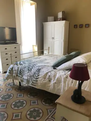 a bedroom with a bed and a dresser at Appartamento Vento D'Estate in Bagheria