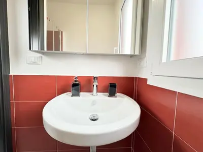 a bathroom with a white sink and a mirror at Attico Magnificent [Wi-Fi/Free Parking] in Palermo