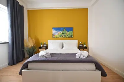 a bedroom with a large bed with towels on it at iFlat Normanni Lounge Apartment in Palermo
