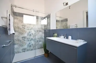 a bathroom with a shower and a sink and a mirror at iFlat Normanni Lounge Apartment in Palermo
