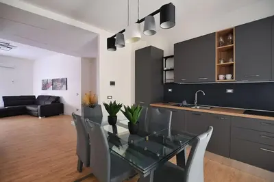 a kitchen and dining room with a glass table and chairs at iFlat Normanni Lounge Apartment in Palermo